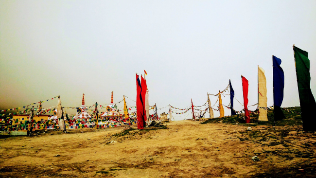 Red and Yellow Prayer flags flutter at Kunzum pass on way to Key Monastery in Spiti valley, Himachal Pradesh.