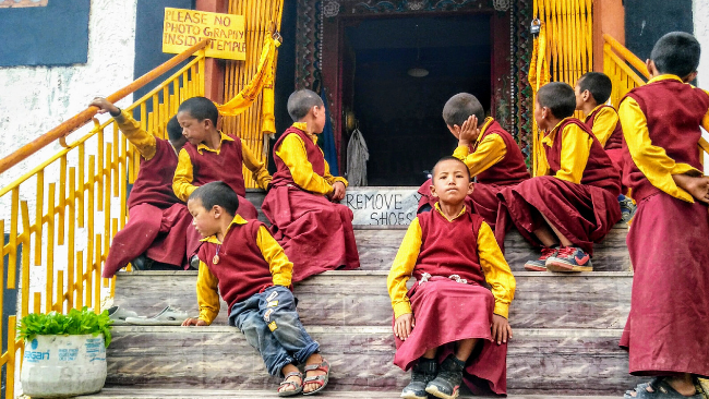 Young Lamas sit at the entrance of the Key Monastery, a religious training centre for Lamas, located on top of a hill at an altitude of 4,166 metres above sea level is the biggest Tibetan Buddhist monastery of Spiti Valley Himachal Pradesh, Lahaul and Spiti district, India.