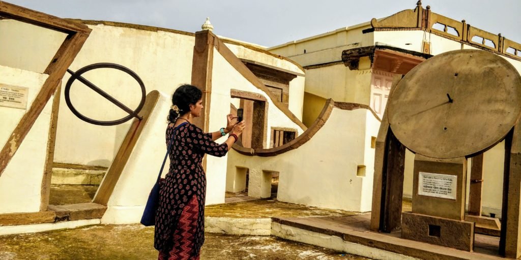 woman taking picture of a giant light and shade watch at Jantar Mantar in Varanasi. Jantar Mantar was constructed with an aim of measuring local time, altitude (of the place)