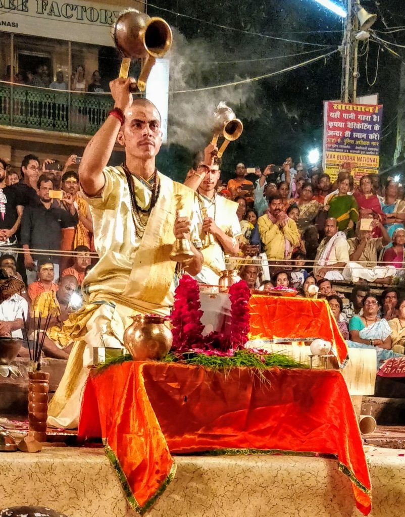 Incense smoke Aarti done by Indian priest dressed in traditional indian attire of dhoti kurta. The aarti is for the Ganges at the Dashashwamedh Ghat, Varanasi.