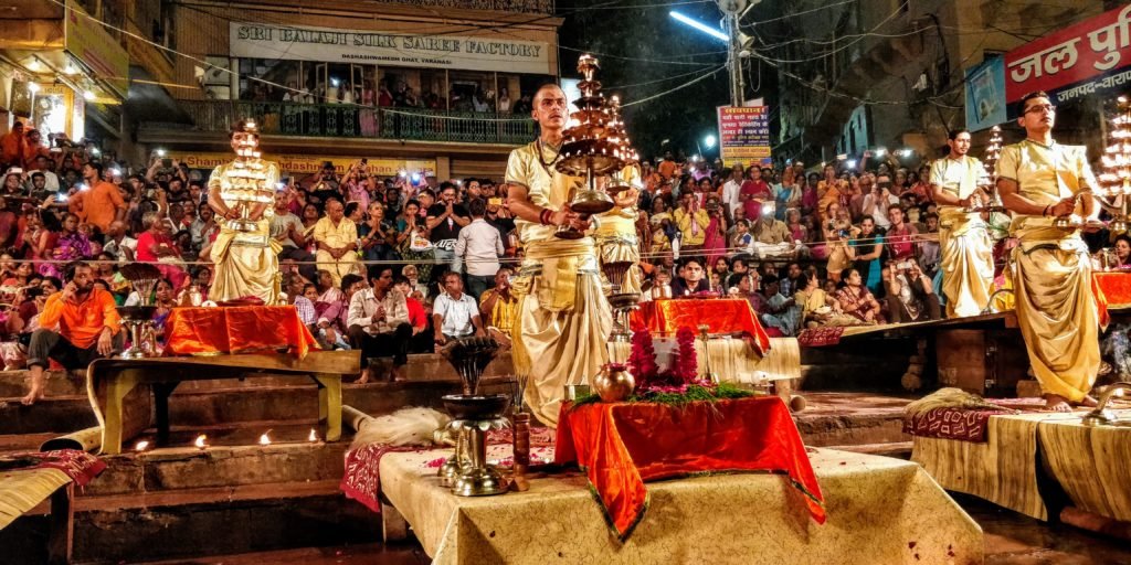 Indian priests dressed in Indian traditional dress of dhoti kurta holding lamps in hand as a part of the ganga aarti in varanasi uttar pradesh