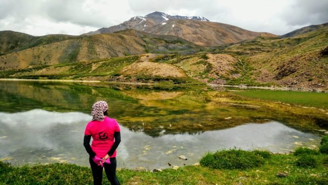 Author looking at Mount Kanamo Peak reflection in lake in  Spiti, Himachal Pradesh, India (at 19600 feet)