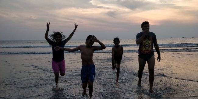 kids play at the srivardhan beach takes hues of blue as the sun sets in the Arabian sea