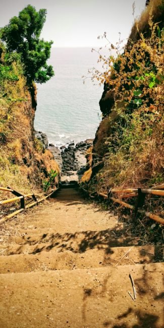 70 steps cut into the laterite rock near the 16th century red roof red and yellow coloured Shiva temple in Harihareshwar in konkan near diveagar beach in Maharashtra