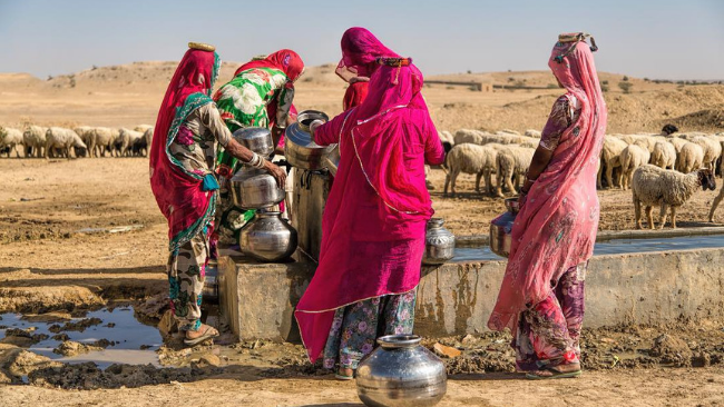 Colourfully attired women fetching water from the well in the desert of Rajasthan and Rann of Kutch. Visit this place with Taurus the Luxury truck in India