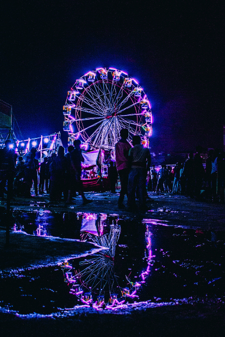 Ferris Wheel lit in purple colour at night at the Surajkund Mela